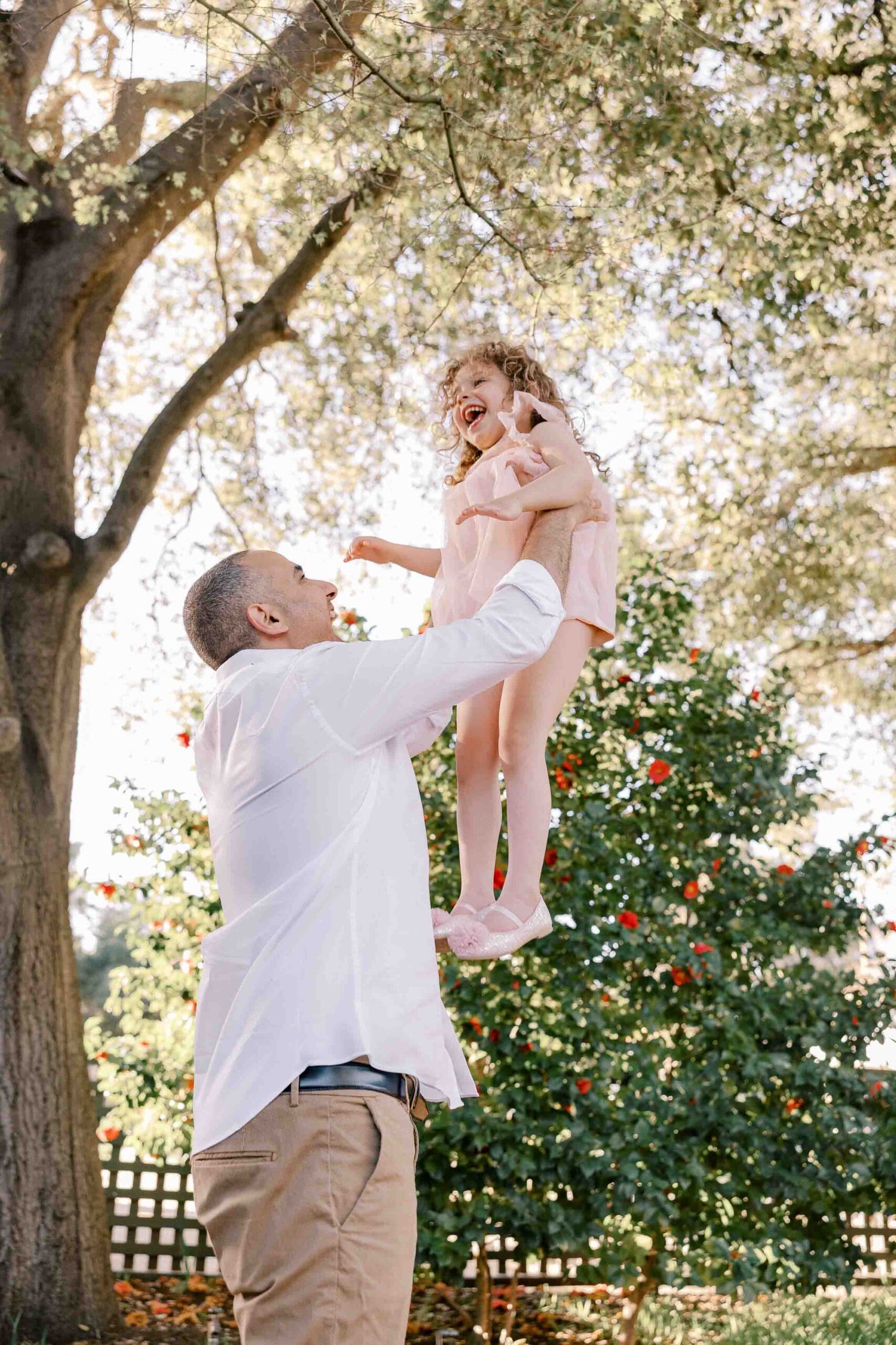 Dad throwing daughter up in air