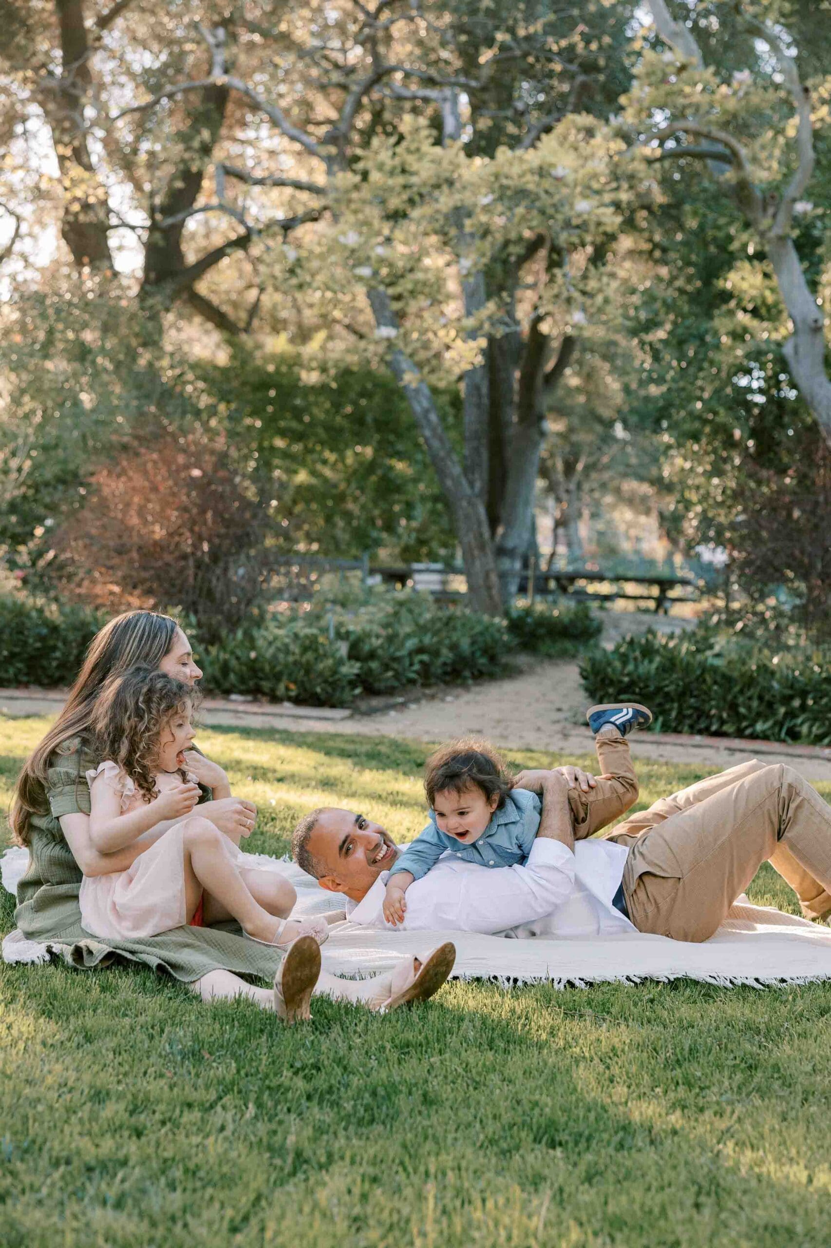 family having tickle fight on the grass in Palo Alto