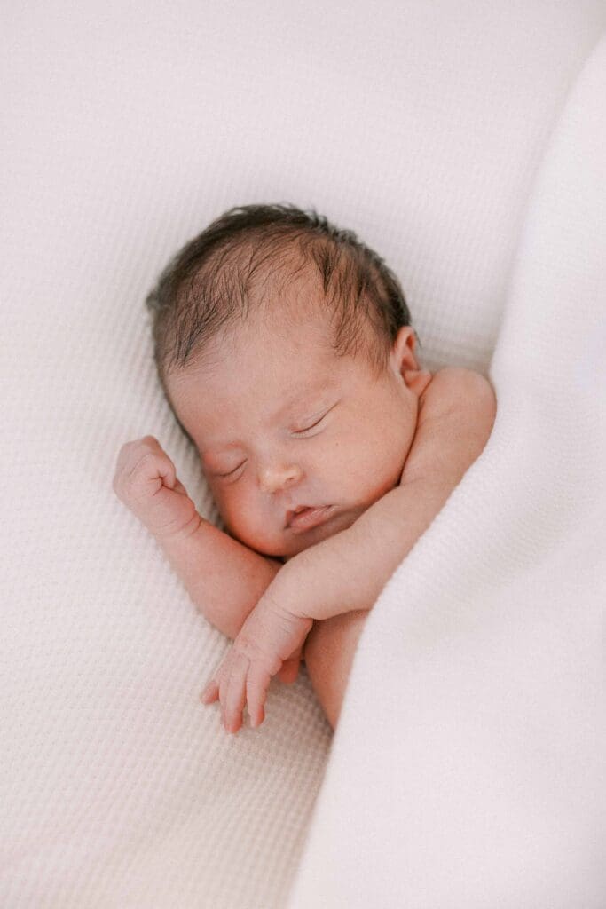 Newborn baby girl wrapped in white blankets in her San Francisco apartment