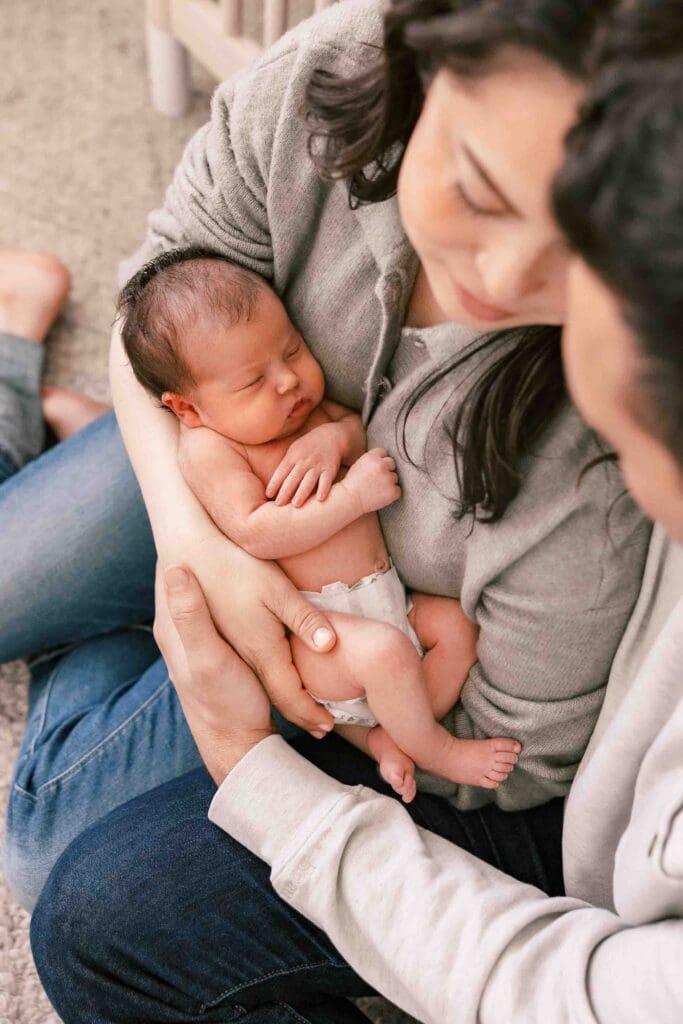 San Francisco new parents closing their eyes and snuggling their new baby