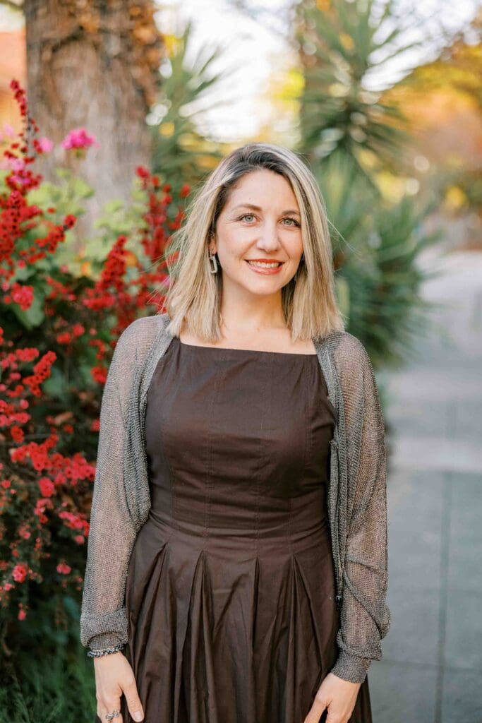Blonde woman wearing a brown dress and sheer cardigan
