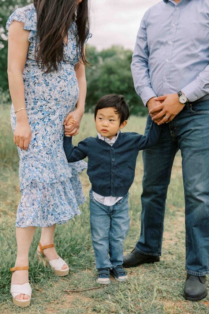 Little boy holding his parents hands