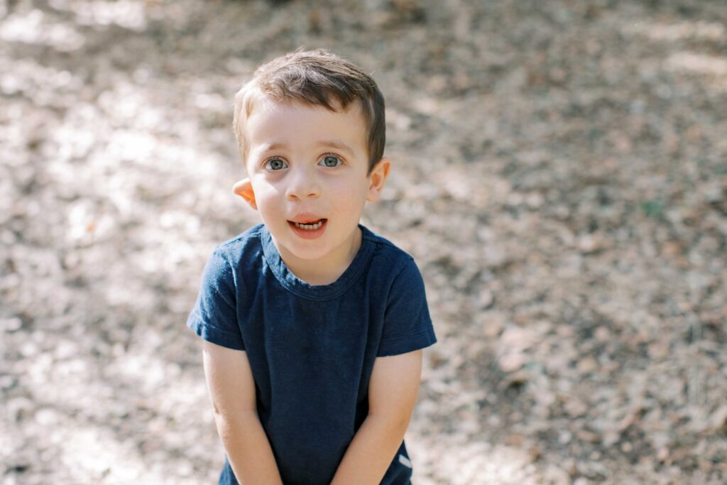 Young boy smiling outdoors in natural light, representing a happy child who might enjoy a gift from Palo Alto toy stores