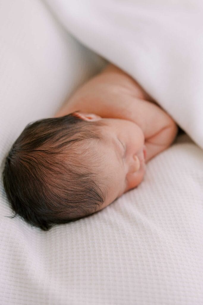Newborn baby girl wrapped in white blankets