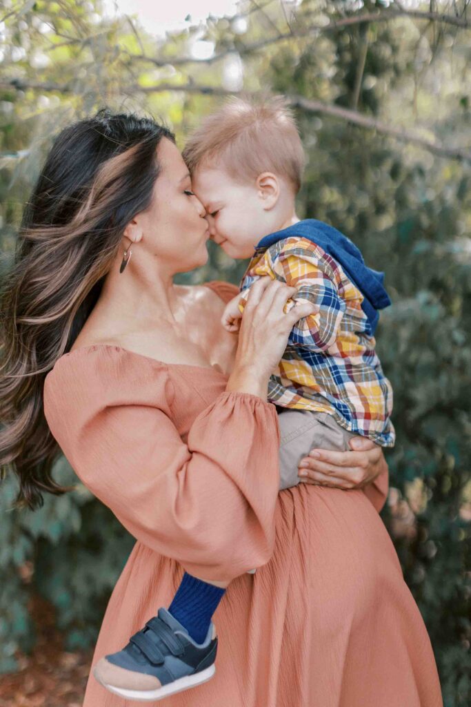 Maternity portrait of a mother holding her toddler on her big belly