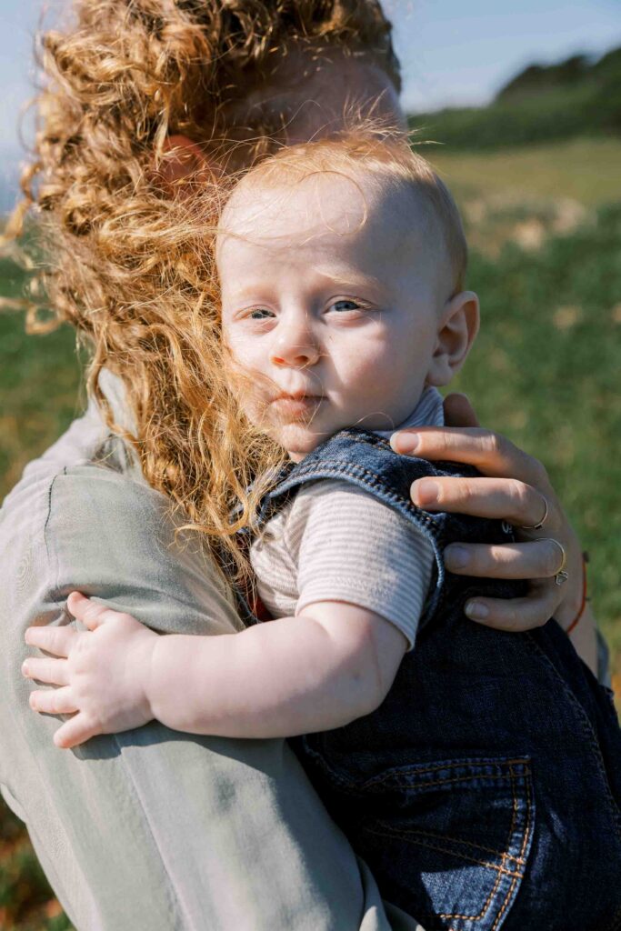 Mother holding her baby boy on a beach