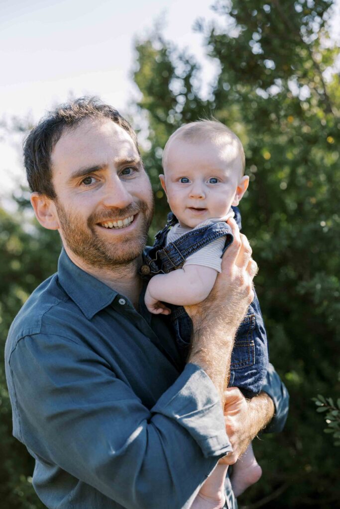 Dad holding his baby boy at the beach