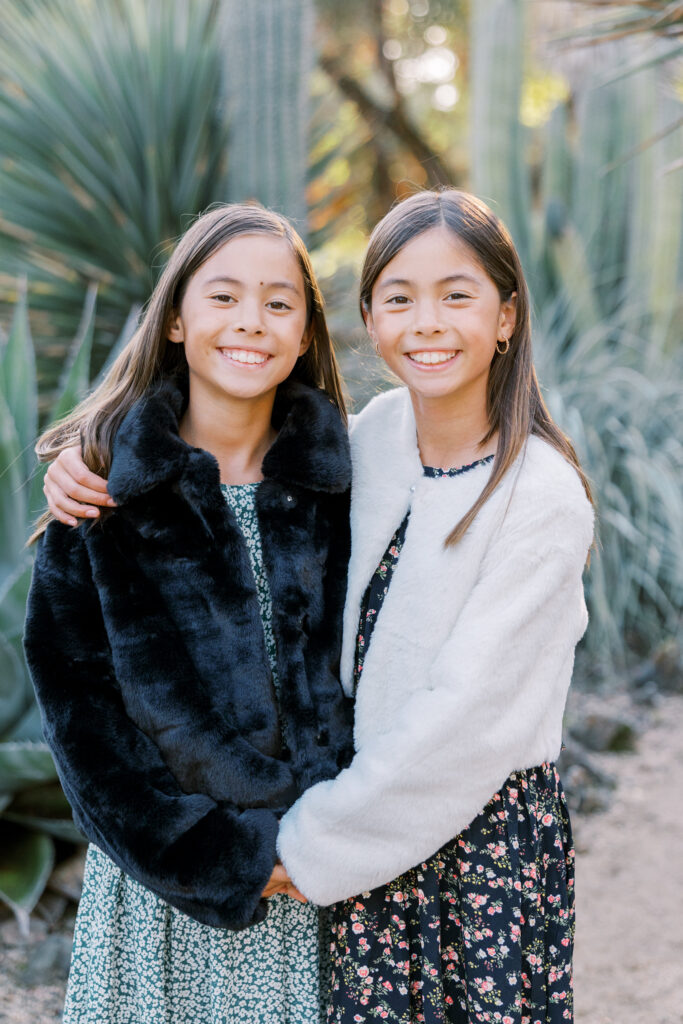 Twin sisters holding hands in the Arizona Cactus Garden at their Bay Area Mini Sessions