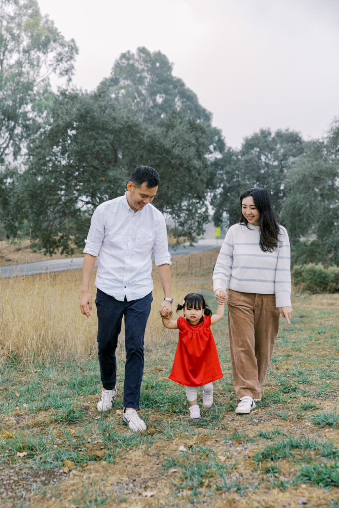 Parents holding hands with their toddler