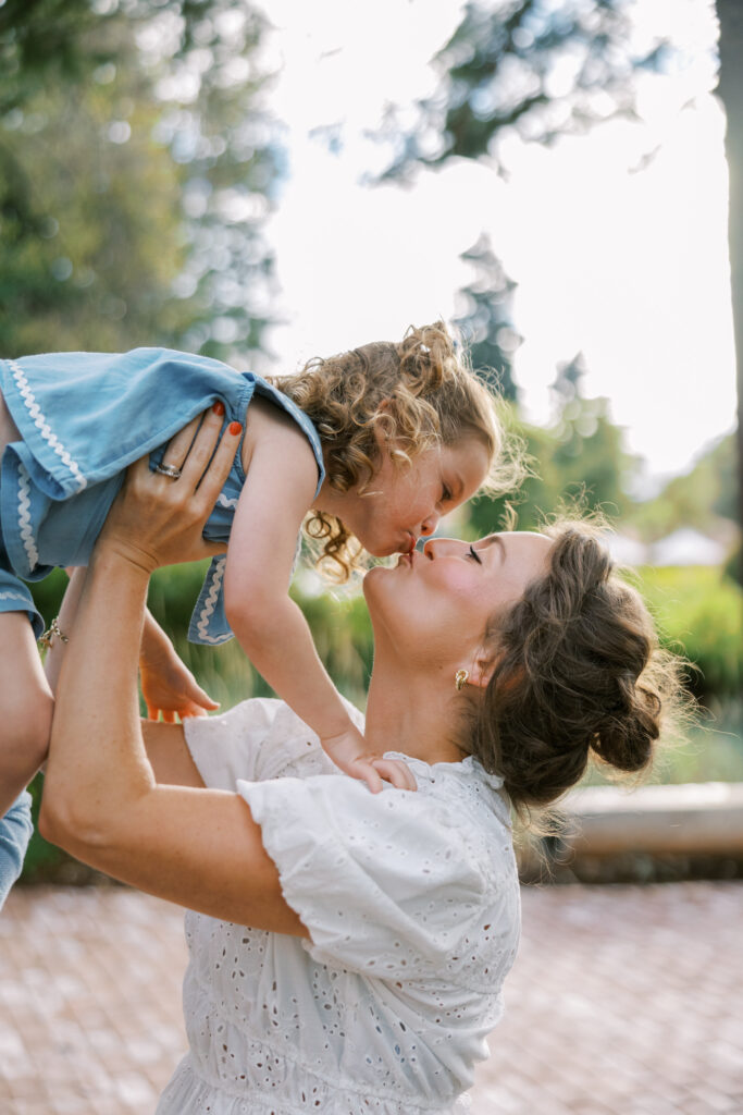 Mother lifting toddler daughter and giving her a kiss during Bay Area Mini Sessions