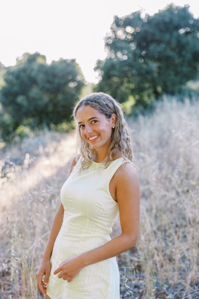 High school senior standing in tall, dry grass at Foothills Nature Preserve